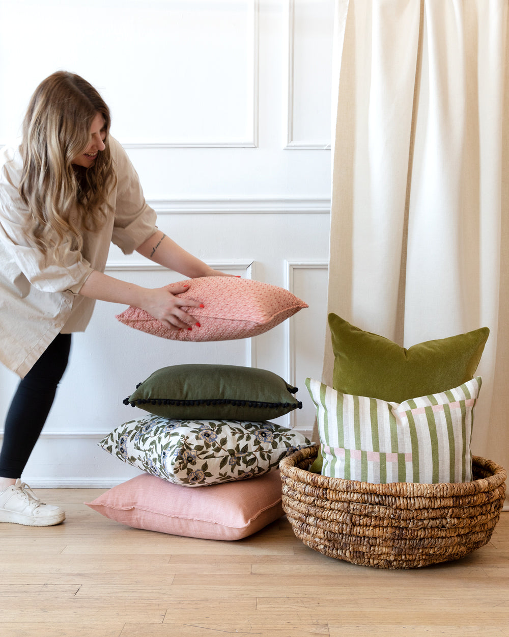 Woman placing pillow on stack of custom pillows