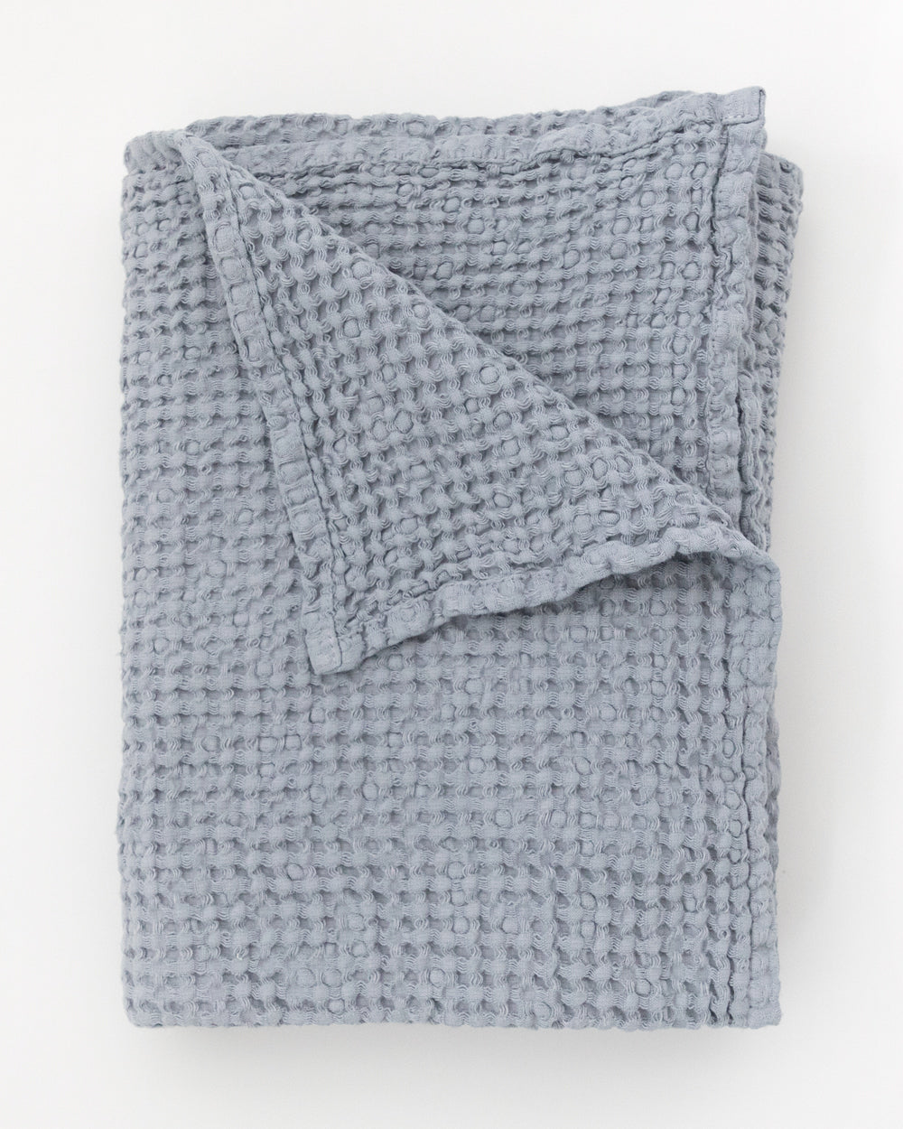 Flat folded blue grey waffle bath towel.