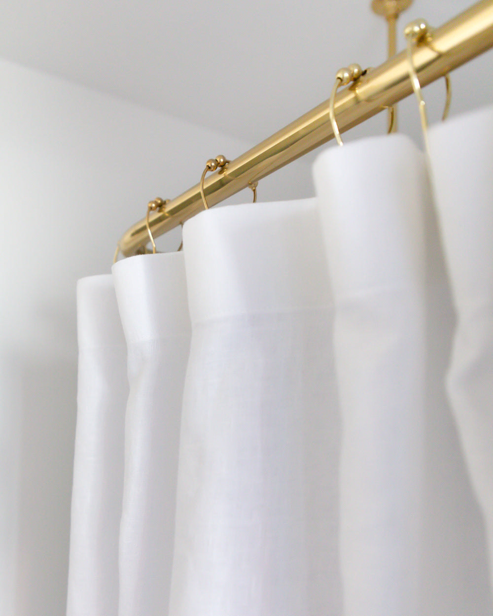 Close up detail of white and natural colour-blocked linen shower curtain
