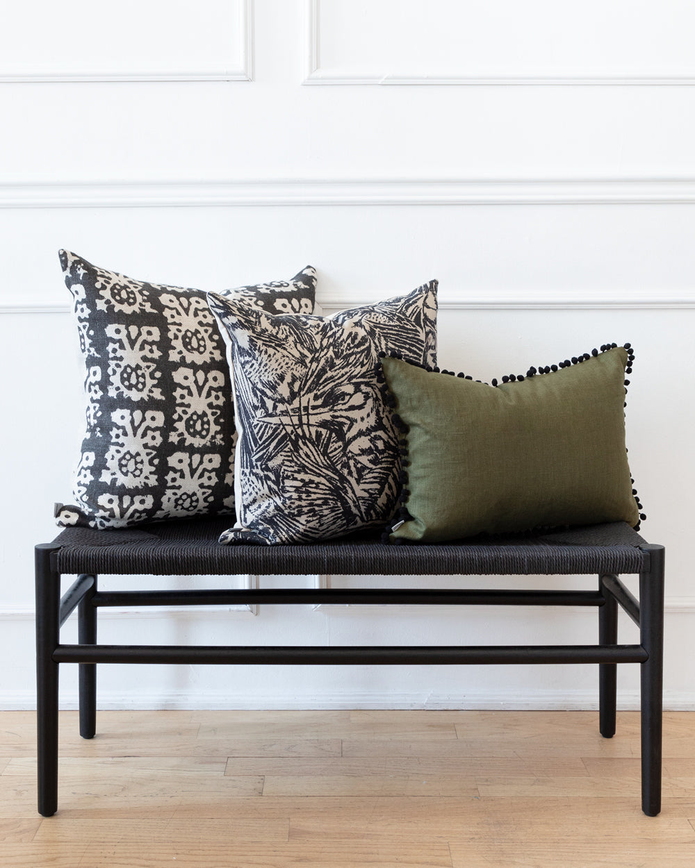 Linen abstract bird pattern pillow on black bench with Hemme complimentary pillows