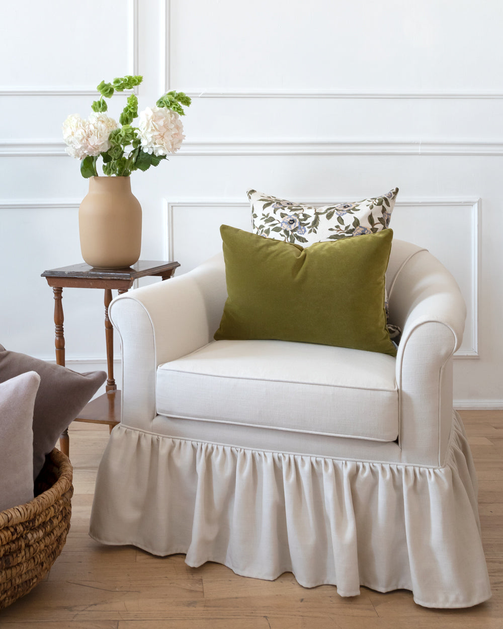 Green moss velvet pillow on white sofa with complimentary Hemme pillow