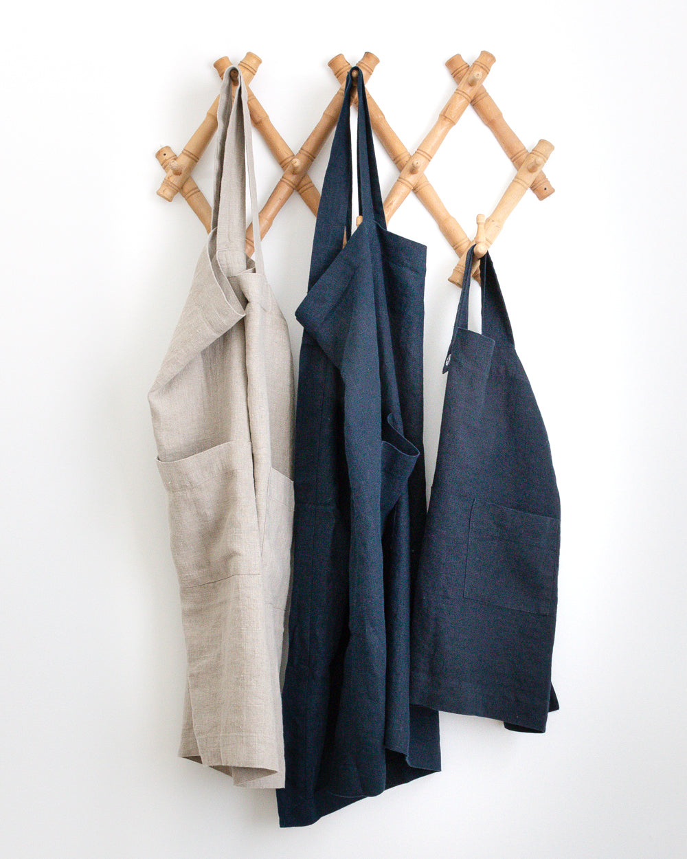 Wall hanger holding three Linen Smock Aprons