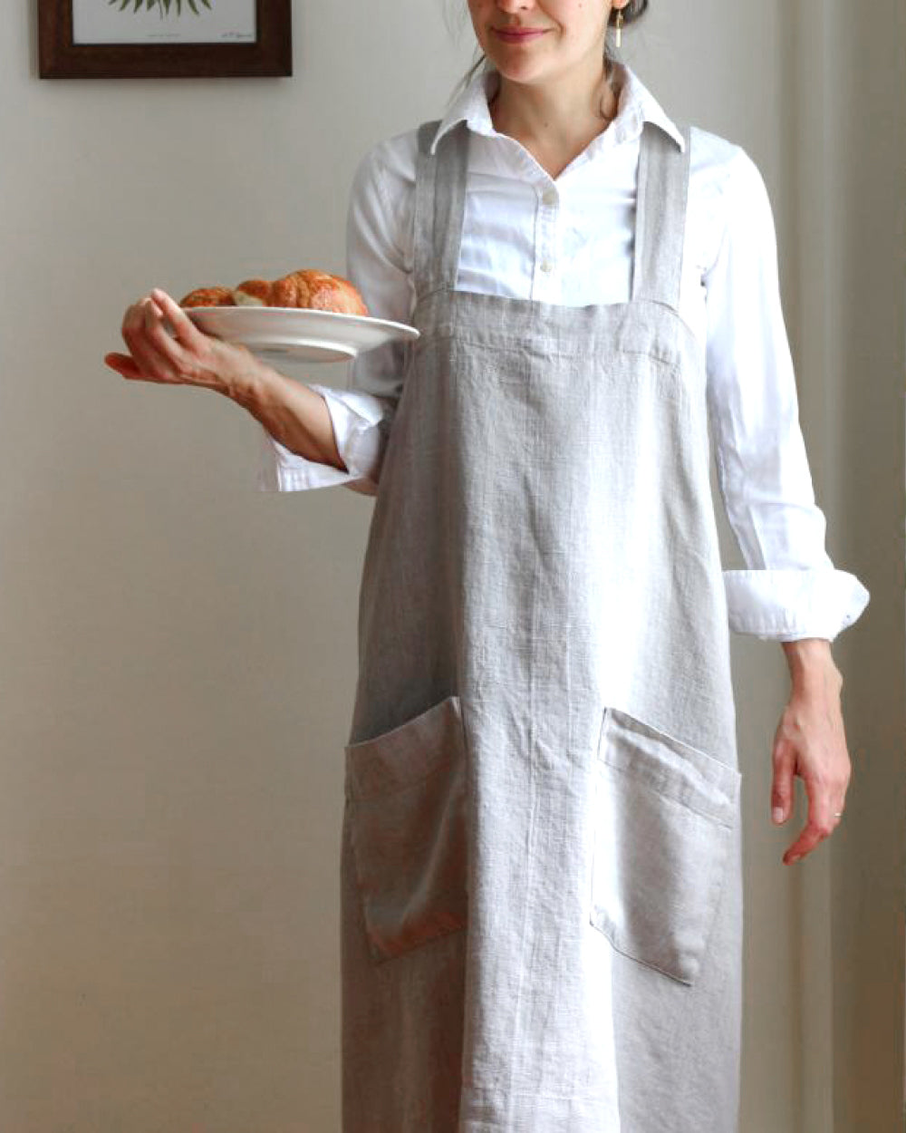 Person holding plate and wearing natural stone-washed linen apron