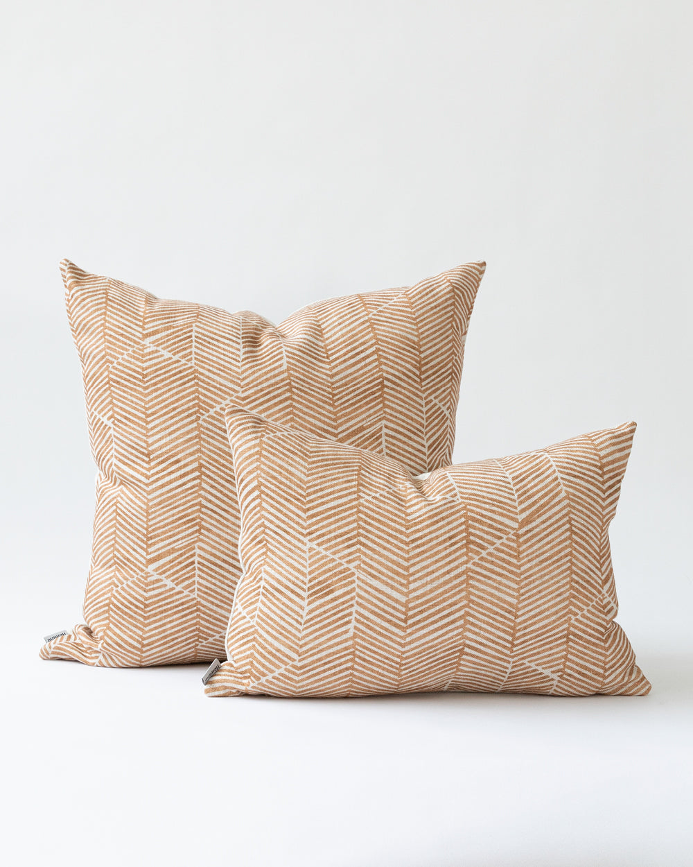 Two rust chevron Imogen Heath patterned pillows