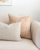 Rust chevron Imogen Heath patterned pillow on white sofa with rectangle polka dot pillow. 