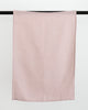 Light pink linen tea towel hanging on black rod.