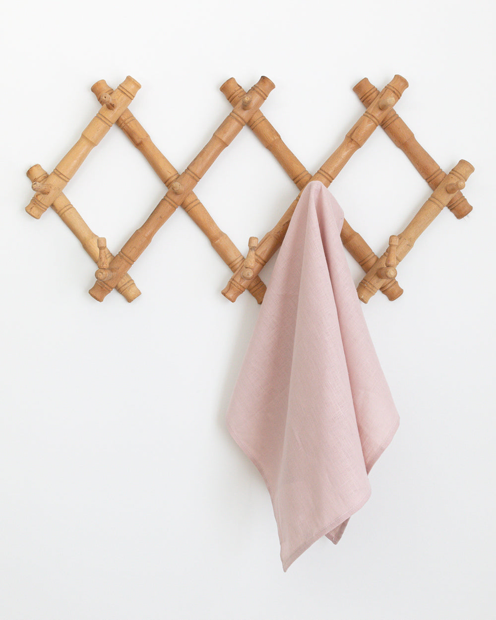 Light pink linen tea towel hanging wall rack.