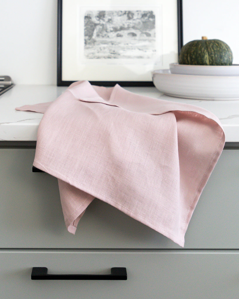Light pink linen tea towel on grey counter.