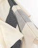Detail close up of lush stone greys and cream throw blanket hanging on black rod.