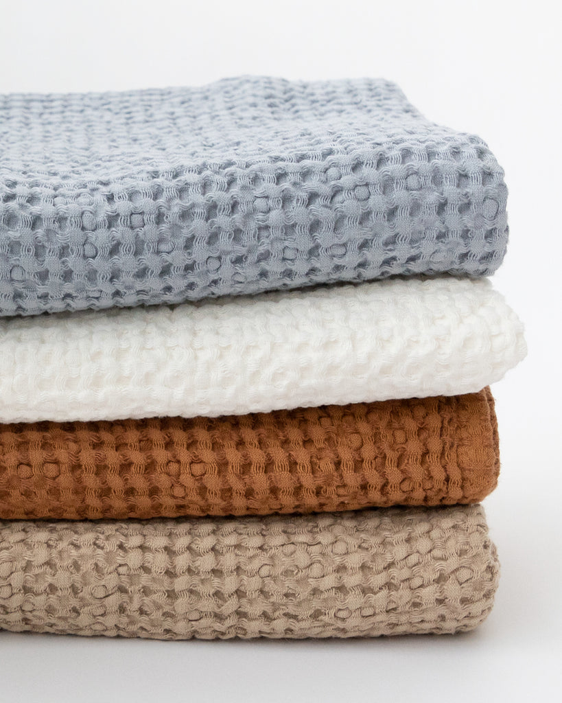 Pile of different colour linen-cotton waffle bath towels.