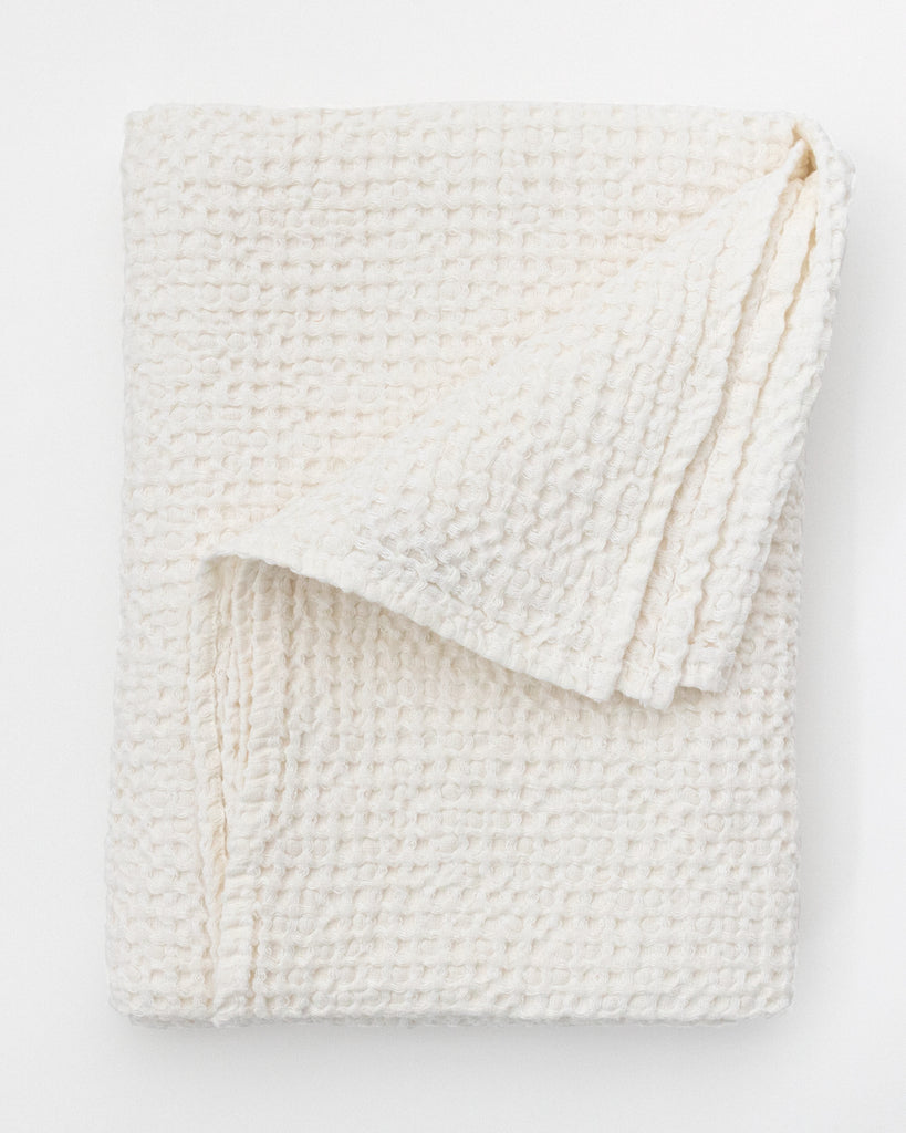 Flat folded warm white waffle bath towel.