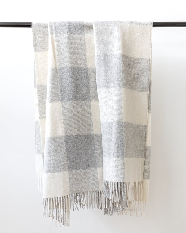 Classic grey Buffalo check blanket woven in soft wool hanging on black rod..