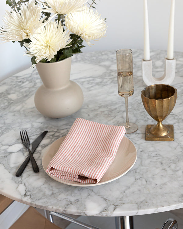Tabletop setting with striped linen tea towel is a beautiful mix of cream and vermillion red