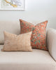 Salmon coloured vintage vintage floral print from the 80s pillow sitting on white sofa with rust chevron complimentary pillow