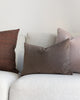 Soft brown velvet pillow placed on a white sofa with mauve mohair and brown linen complimentary pillows