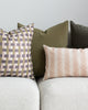 Soft olive green velvet pillow on white sofa paired with complimentary pillows