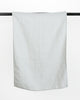 Blue stonewashed linen tea towel hanging on black rod