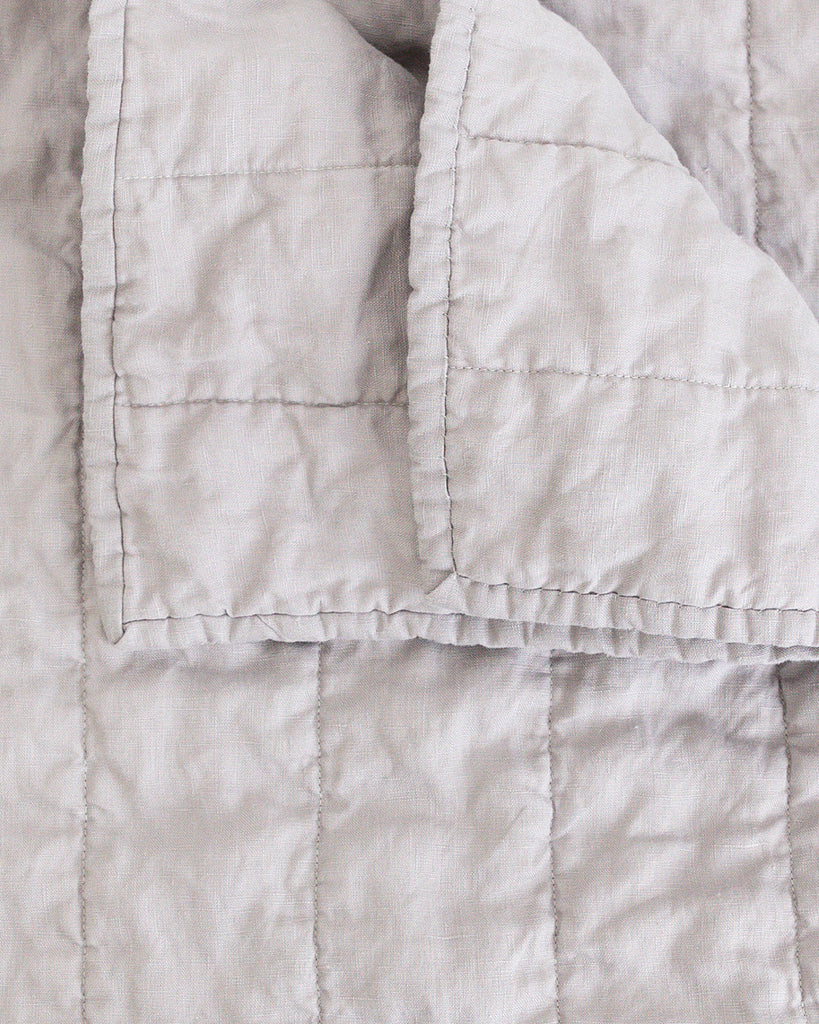 Close up detail of classic light grey quilt