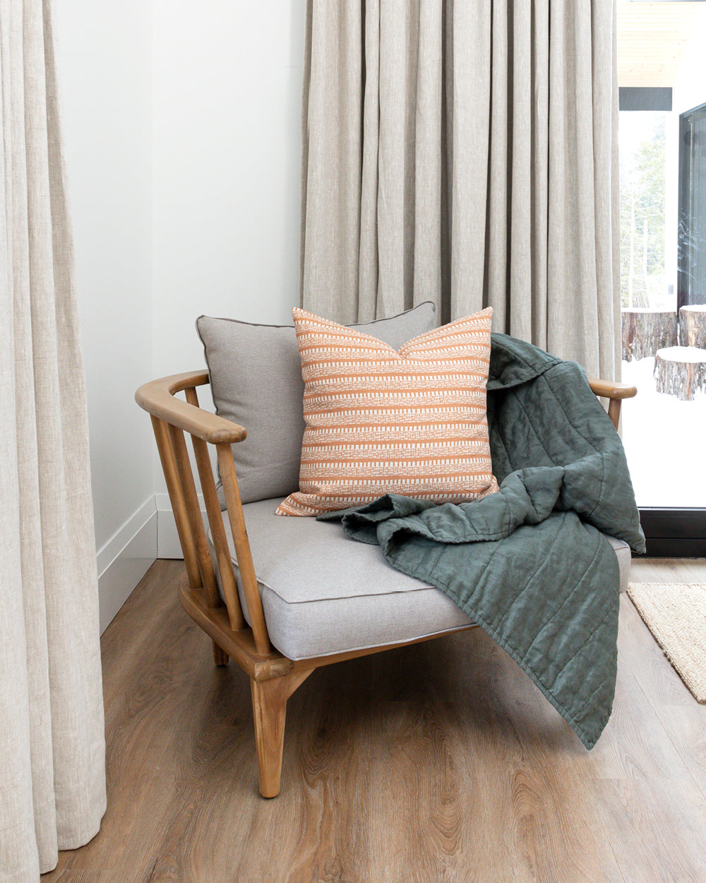 Dark green colour handmade Linen Quilt on armchair with complimentary striped rust Hemme pillow