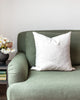 Grey and white organic swirl pattern pillow on green sofa 