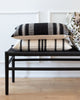 Black and cream striped lumbar pillow on black bench with complimentary Hemme pillows