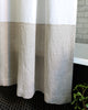 Close up detail of white and natural colour-blocked linen shower curtain