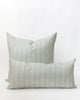 Two pillows with a subtle white floral/vine stripe on a misty grey-blue background