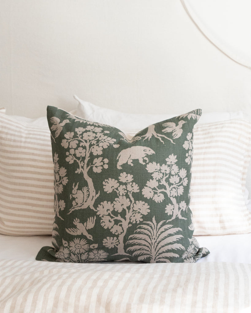 Green and beige woodland print pillow on striped duvet